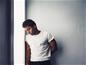 Homme debout contre le mur